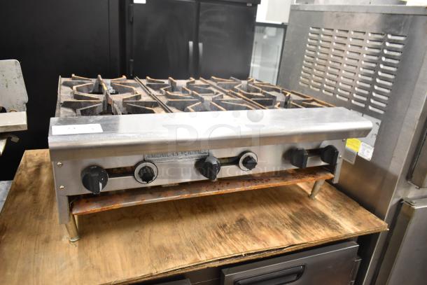 American Range commercial countertop gas-powered 6-burner range in used condition, sturdy knobs, and visible brand logo.