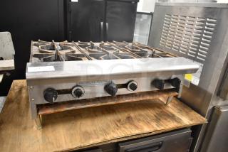American Range commercial countertop gas-powered 6-burner range in used condition, sturdy knobs, and visible brand logo.