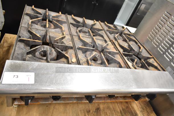 American Range commercial countertop gas-powered 6 burner range, worn condition, with visible dials and control panel.