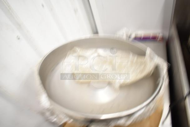 Blurry image showing a metal pizza pan in a storage setting. Details unclear. Auction includes various items including lightbulbs.