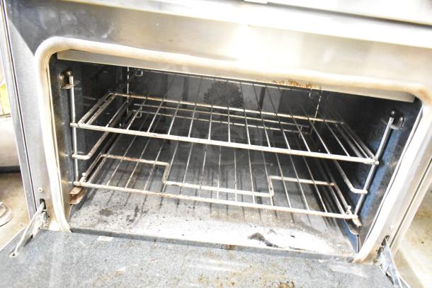 Thermador Professional 4-burner range with convection oven, stainless steel, visible wear and soiling inside oven.