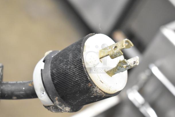 Bunn IMIX-5 commercial cappuccino machine plug viewed up close, showing three-prong connection, moderate wear visible.