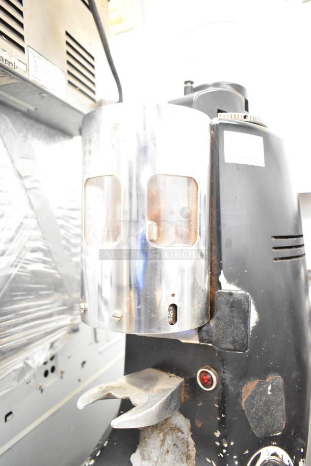 Mazzer Luigi ROBUR espresso bean grinder, countertop model. Black with metal hopper, visible wear. 115 volts, 1 phase.