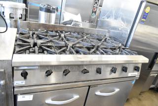 US Range Commercial countertop gas-powered 8-burner range, stainless steel, used condition, visible control knobs, US Range logo.