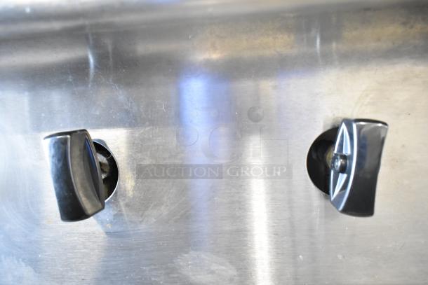 US Range commercial gas-powered countertop range controls, stainless steel, two burner knobs visible, good condition.