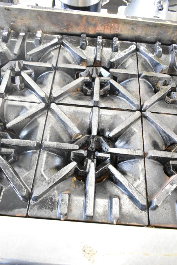 US Range commercial 8 burner countertop gas range, used condition, showing metal grates and slight wear.