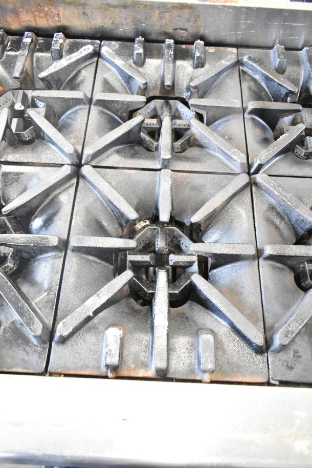 US Range commercial countertop gas-powered 8 burner range; cast iron grates; used condition with visible wear.
