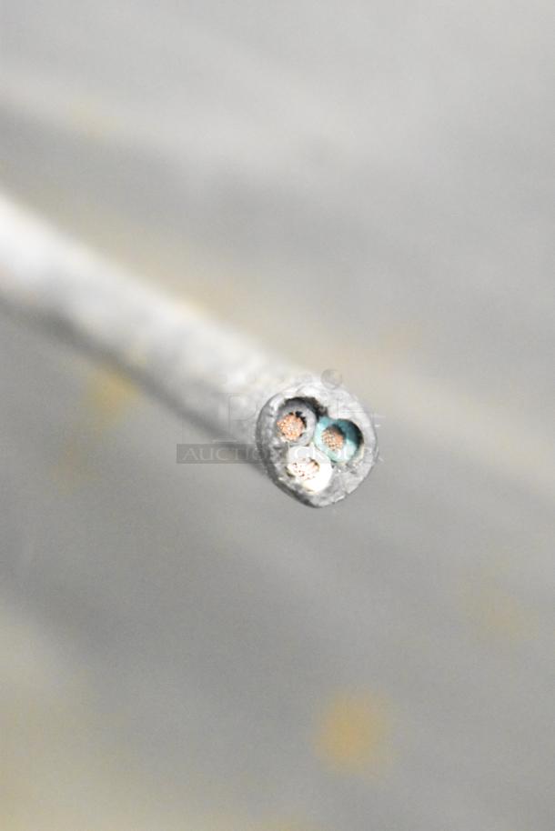 A close-up of a cut power cable showing internal copper wires, likely part of a Hollymatic 180 Meat Mixer Grinder.