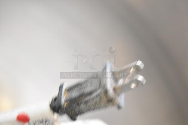 Blurry image of a plug for a Cleveland KEL-100 commercial 100-gallon electric kettle, 208/240 volts, details unclear.