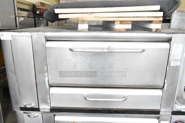 2 commercial stainless steel gas-powered single burner pizza ovens with cooking stones. Handles and markings visible.