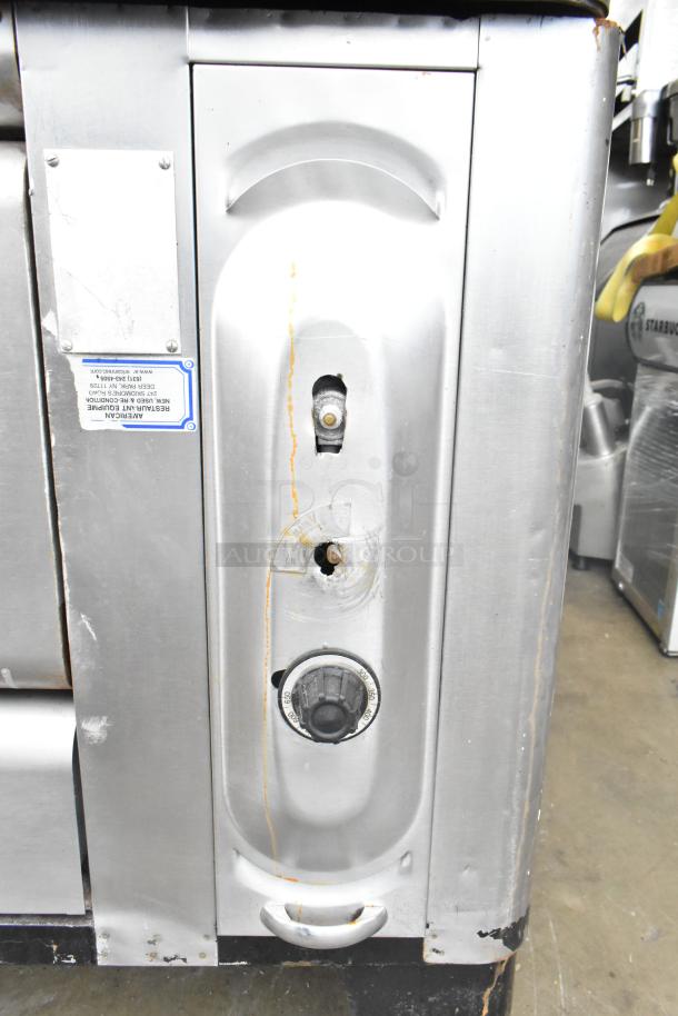 2 commercial gas-powered single burner pizza oven with cooking stones, visible wear, and control knobs.