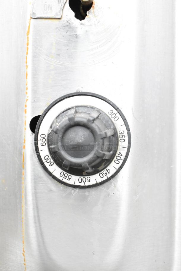 Close-up of a commercial gas-powered pizza oven control knob, showing temperature settings from 300 to 650 degrees.