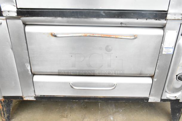 2 commercial gas-powered single burner pizza ovens with cooking stones, stainless steel, visible wear, auction item.