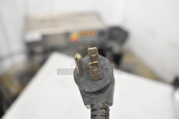 Delfield 406CA-DHL-DD1 undercounter cooler plug. 115V, 1 phase. Black plug with metal prongs; background shows unit.