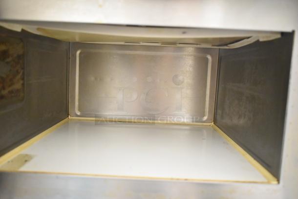 Panasonic NE-17523 commercial microwave interior. Clean, stainless steel finish. Slight wear visible. 208/240 volts.