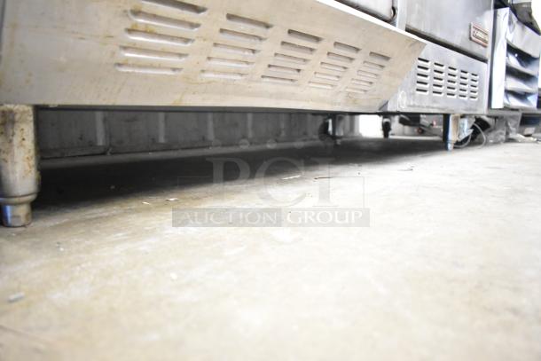 Garland commercial gas 6 burner range with flat top griddle, dual ovens, over shelf, backsplash; used condition.