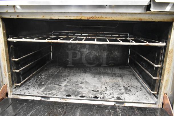 Garland Commercial 6 Burner Gas Range interior with visible oven racks and signs of use.