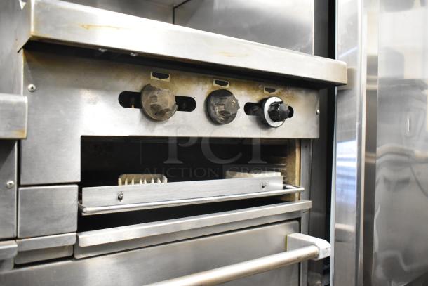 Garland commercial gas range with 6 burners, flat top griddle, 2 ovens, shelf, backsplash. Stainless steel finish. Used condition.