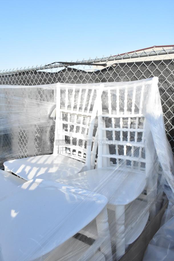 20 new Lancaster Table & Seating white resin Chiavari chairs, wrapped in plastic, visible scratches and dents.