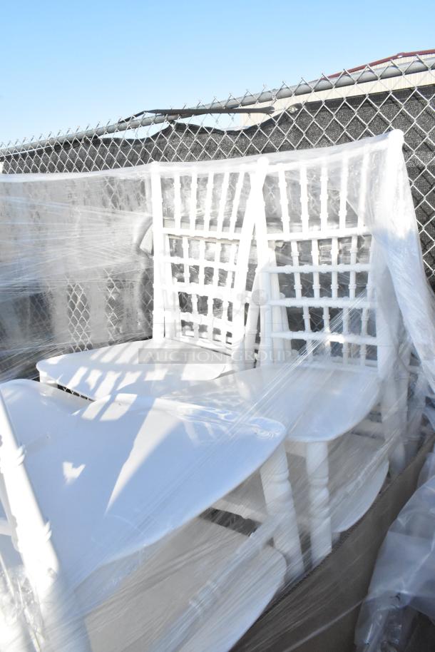 White resin Chiavari chairs by Lancaster Table & Seating, new scratch and dent condition, wrapped in plastic.