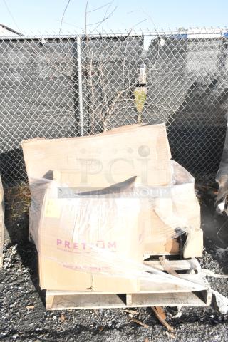 Pallet with boxed items labeled "PRETM" and "FEB26-161," including new scratch and dent stool and seat cushions.