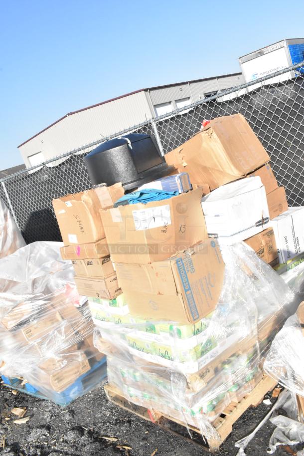 Pallet of assorted scratch and dent items, including La Croix sparkling waters, crackers, and a trash can lid. Boxes visible.