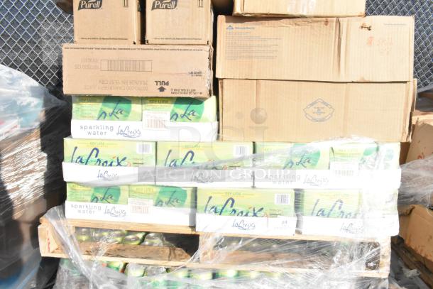 Pallet of La Croix Key Lime sparkling water cases wrapped in plastic, stacked with cardboard boxes. Items are scratch and dent.