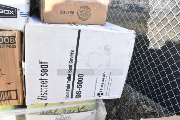 Boxes of discreet seat DS-5000 toilet seat covers, La Croix, and other items in original packaging, new condition.