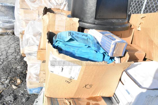 Box of assorted items including blue plastic bags and cardboard packaging, labeled with shipping tags. Scratch and dent condition.