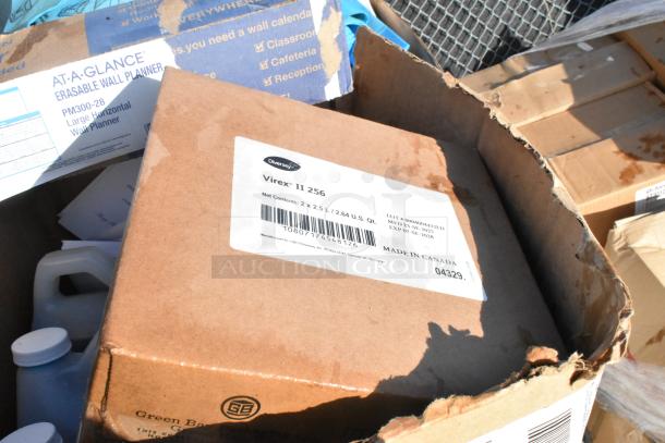 Cardboard box labeled "Diversey Virex II 256" with 2.5L bottles. Includes wall planner box, showing varied new items.