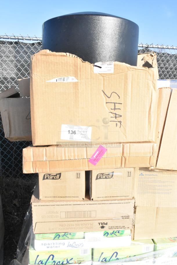 Stack of boxes with La Croix sparkling water, Purell, and a black trash can lid, marked as scratch and dent items. 65 items total.