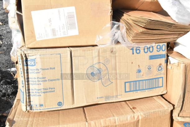 A stack of boxed Tork high-capacity tissue rolls, labeled with product details, showing scratch and dent condition.