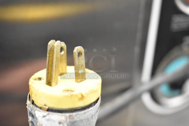 Plate Mate Commercial Heated Holding Cabinet plug detail, shows three-prong, metal connector; background shows control panel.