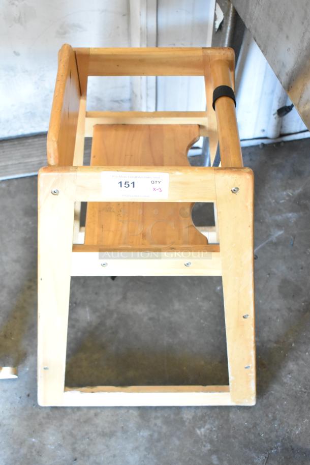 Wooden high chair, natural finish, used condition, visible scuff marks. Tag indicates quantity of three available.