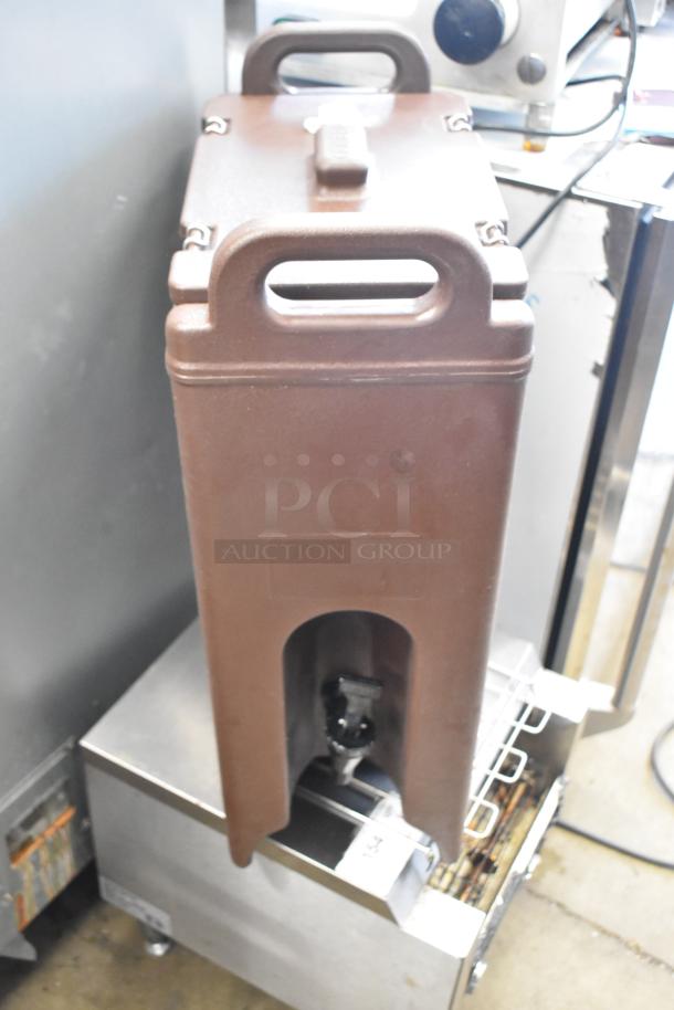 Two Cambro brown poly beverage dispensers, durable and insulated, with handles and spouts, in good condition.