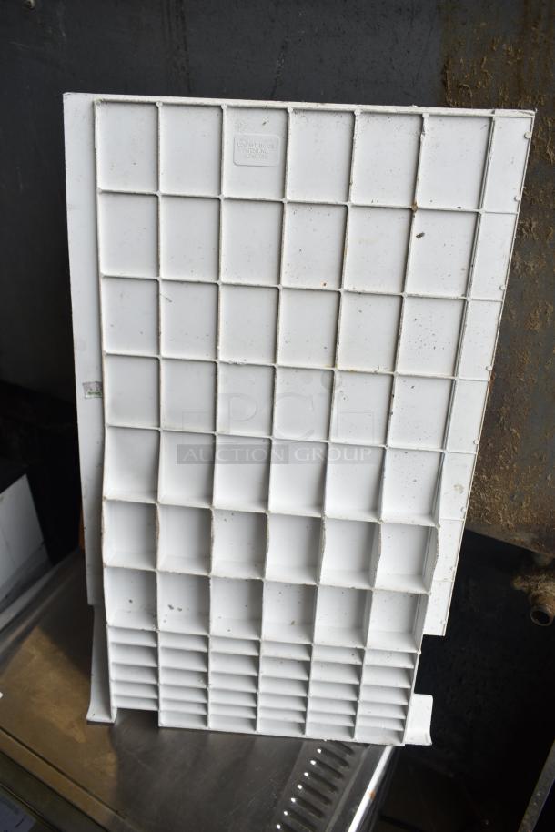 Alt Text: White plastic grid-like panel, used and slightly discolored, possibly part of a utilitarian kitchen equipment set.