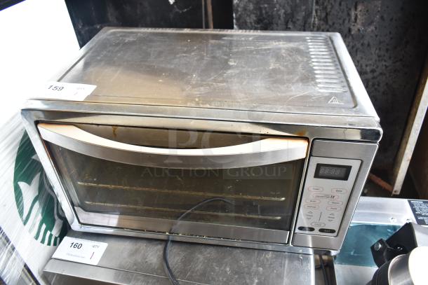 Oster TSSTTVDGXL countertop toaster oven, stainless steel, digital controls, visible wear, 120V, 1 Phase, auction tag visible.
