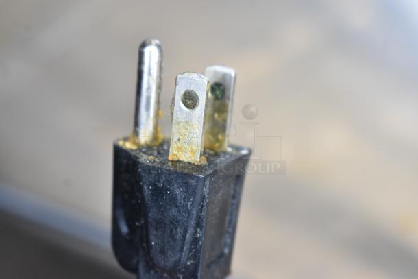 Corroded plug of Templeton Commercial Countertop Microwave Oven, 120 Volts, 1 Phase. Visible wear on prongs.