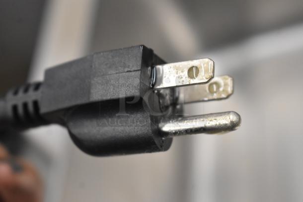 Close-up of a plug for Winco FW-S500 Countertop Food Warmer, 120 Volts, 1 Phase, showing prongs and black plastic casing.