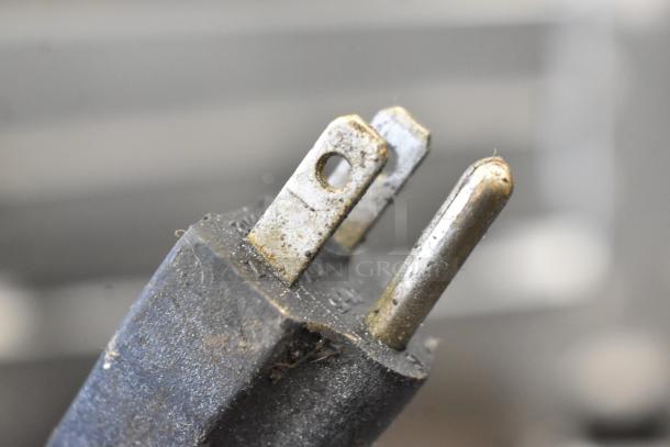 Close-up of a slightly worn electrical plug for the Qualite FW-1200WF Countertop Food Warmer.