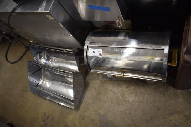 Countertop roll top chafing dish with shiny finish and two extra lids, in good condition. Auction tag visible.