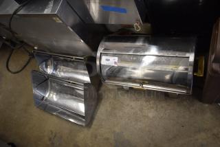 Countertop roll top chafing dish with shiny finish and two extra lids, in good condition. Auction tag visible.