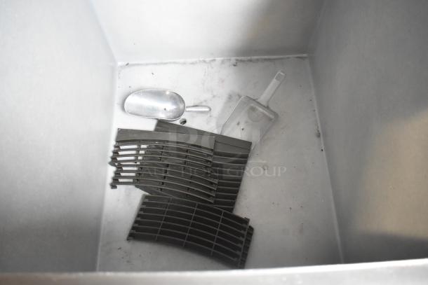 Interior of Manitowoc SY0854A Commercial Ice Bin showing ice scoops and grates. Used condition, 208-230V, 1 Phase.