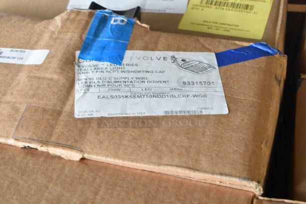 Cardboard box labeled "Evolve LED Series Area Light" showing catalog number, voltage, and assembly details, in good condition.
