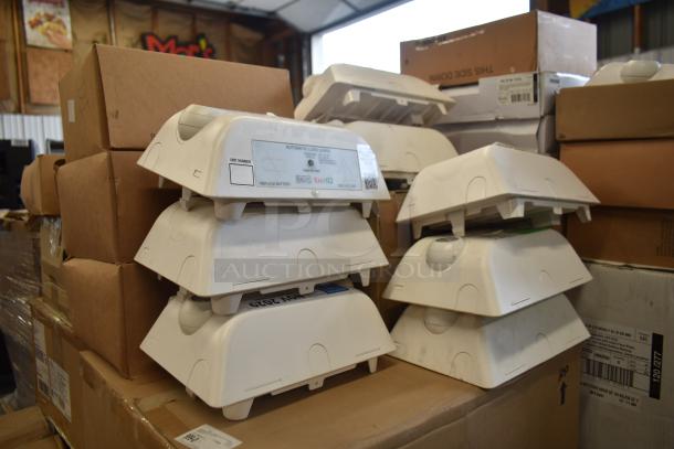 Stack of Dual Lite LED emergency lights on boxes, various models, labels visible, slightly used condition, auction lot of 47.