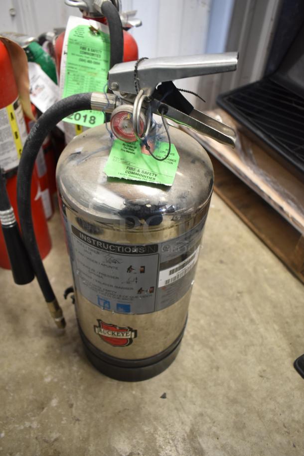 Seven fire extinguishers, mixed brands, one Buckeye visible with safety tags. Good condition, pickup only.