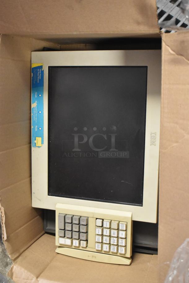 IBM monitor with built-in numeric keypad in used condition, packaged in a cardboard box. Visible wear on the frame.