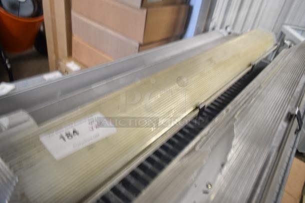 Four linear light fixtures with translucent ribbed covers, model 184 visible. Good condition, slightly distorted image.