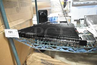 BRAND NEW Estella 34815657 evaporator coil for MCC220, scratch and dent condition, shown on metal shelving with auction tag.