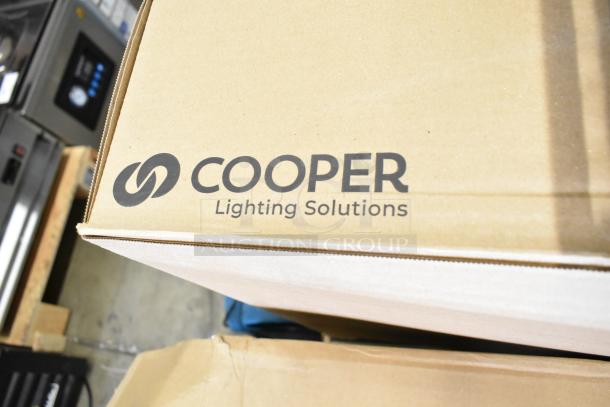 Box labeled "Cooper Lighting Solutions" containing 4 brand new scratch and dent light fixtures.